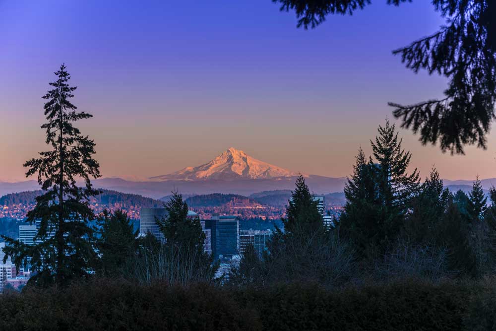 Mount Hood at sunset with Portland, Oregon skyline in foreground.